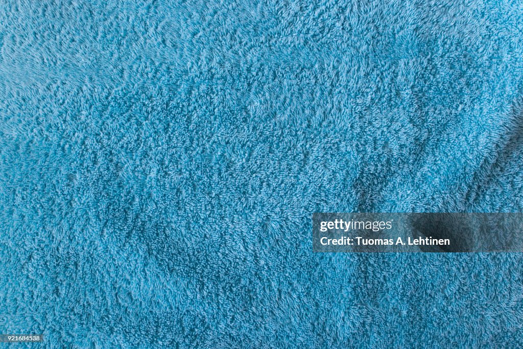 Close-up of soft turquoise towel texture background viewed from above.