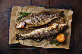 Grilled Fish Sea bass on grill with lemon and rosemary