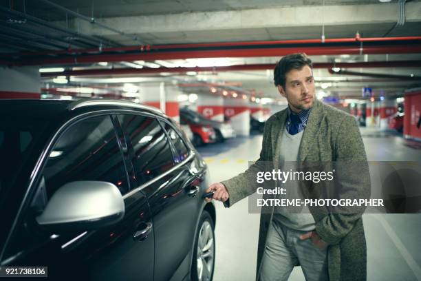 man in the parking garage - unlocking stock pictures, royalty-free photos & images