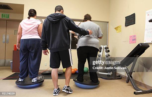 Fitness instructor Jeremy Selan helps seventeen year-old Marissa Hamilton balance on a ball during a fitness class at Wellspring Academy October 19,...