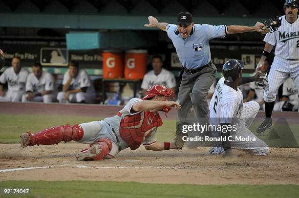 Hanley Ramirez of the Florida Marlins is safe at the plate as Paul Bako of the Philadelphia Phillies tags him late as umpire Dan Iassogna makes the...
