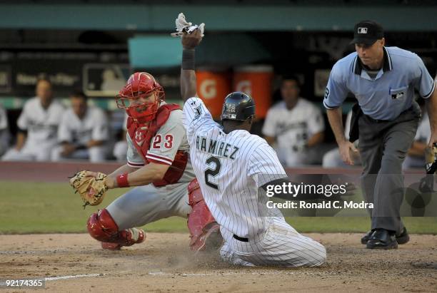 Hanley Ramirez of the Florida Marlins is safe at the plate as Paul Bako of the Philadelphia Phillies tags him late as umpire Dan Iassogna makes the...