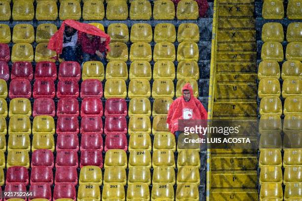 Supporters of Colombia's Independiente Santa Fe wait under the rain for the start of 2018 Copa Libertadores football match against Chile's Santiago...
