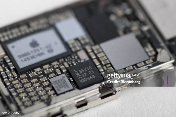 Semiconductors NV controller integrated circuit chip, center, of an Apple Inc. IPhone 6 smartphone is seen in an arranged photograph in Bangkok,...