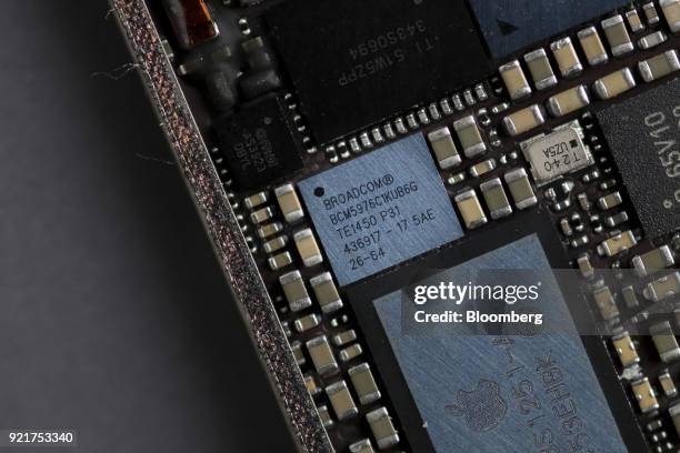 Broadcom Corp. Touch screen digitizer integrated circuit chip, center, of an Apple Inc. IPhone 6 smartphone in seen in an arranged photograph in...