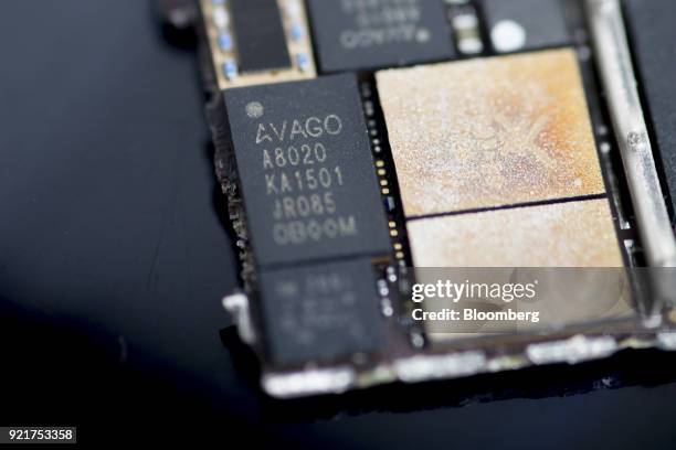 An Avago Technologies Ltd. Power amplifier module chip, center left, of an Apple Inc. IPhone 6 smartphone is seen in an arranged photograph in...