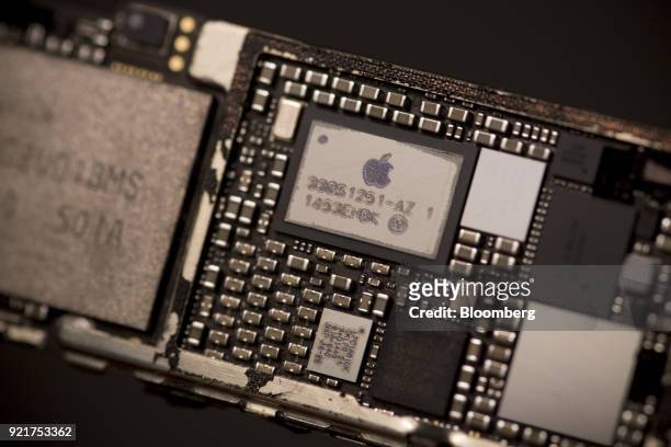 The Apple Inc logo is seen on the power management supply integrated circuit chip mounted in the logic board of an iPhone 6 smartphone in an arranged...