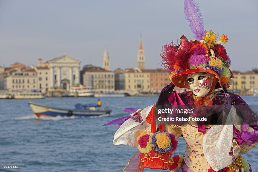 Weibliche Maske mit bunten Kostümen im Grand Canal in Venedig