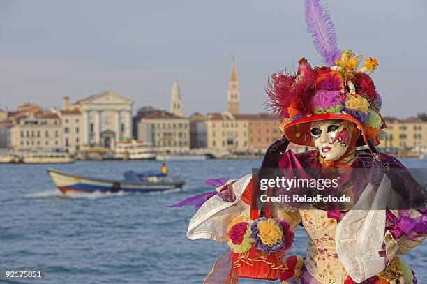 weibliche maske mit bunten kostümen im grand canal in venedig - venezianische karnevalsmaske stock-fotos und bilder