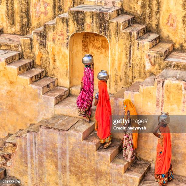 indian women carrying water from stepwell near jaipur - stepwell india stock pictures, royalty-free photos & images