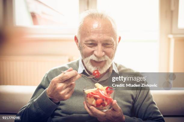 i love vegetable snack. - senior adult eating stock pictures, royalty-free photos & images