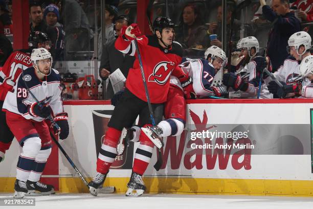 Brian Boyle of the New Jersey Devils pushes Josh Anderson of the Columbus Blue Jackets into the bench during the game at Prudential Center on...