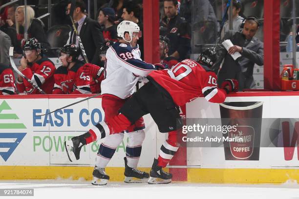 Boone Jenner of the Columbus Blue Jackets pushes Jimmy Hayes of the New Jersey Devils during the game at Prudential Center on February 20, 2018 in...