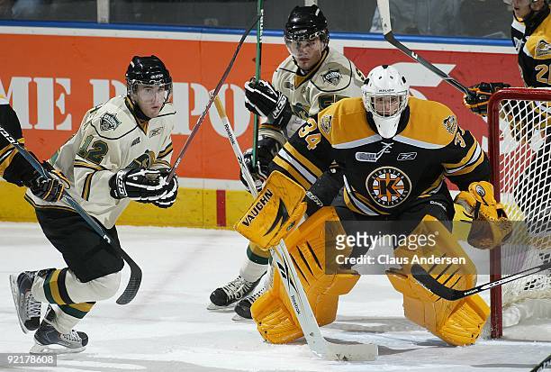 Tyler Beskorowany of the Kingston Frontenacs watches for a shot with Pieter Schinkelshoek of the London Knights looking for a rebound in a game on...