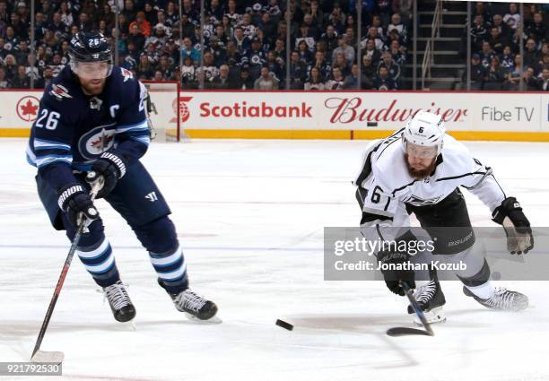 Blake Wheeler of the Winnipeg Jets and Jake Muzzin of the Los Angeles Kings chase the loose puck during first period action at the Bell MTS Place on...