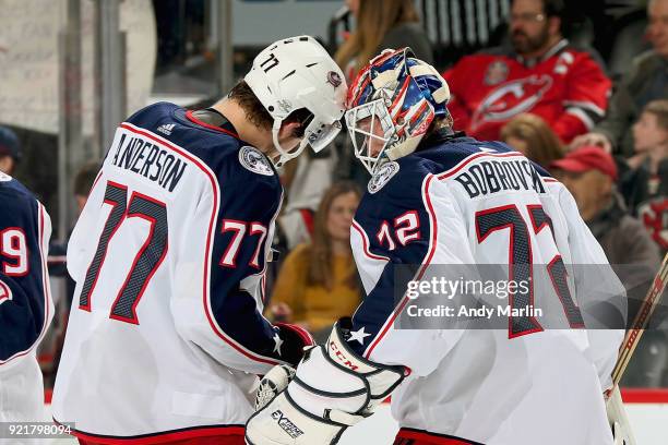 Sergei Bobrovsky of the Columbus Blue Jackets is congratulated by Josh Anderson after defeating the New Jersey Devils 2-1 at Prudential Center on...