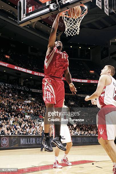 Carl Landry of the Houston Rockets dunks against Rasho Nesterovic of the Toronto Raptors during a preseason game at Air Canada Centre on October 15,...