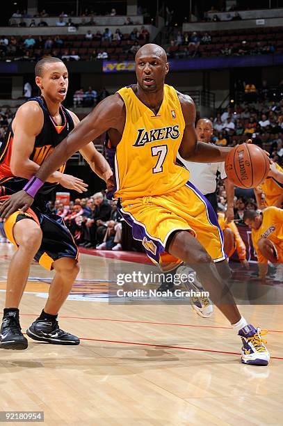 Lamar Odom of the Los Angeles Lakers drives to the basket past Stephen Curry of the Golden State Warriors during the preseason game on October 7,...