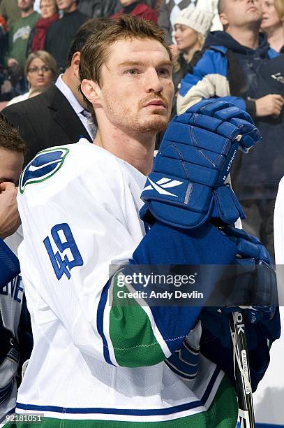 Alexandre Bolduc of the Vancouver Canucks stands for the national anthem before a game against the Edmonton Oilers at Rexall Place on October 19,...