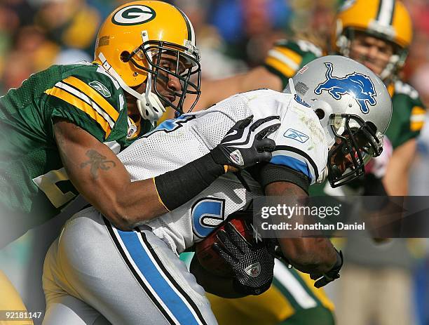 Kevin Smith of the Detroit Lions is tackled by Charles Woodson of the Green Bay Packers reaches in to slow him down at Lambeau Field on October 18,...