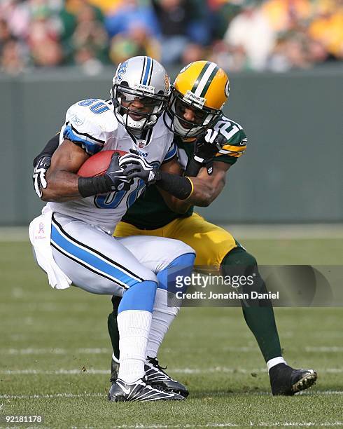 Charles Woodson of the Green Bay Packers brings down Bryant Johnson of the Detroit Lions at Lambeau Field on October 18, 2009 in Green Bay,...