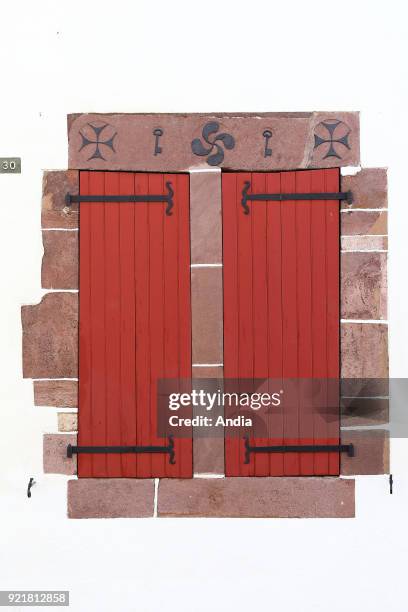 Saint-Jean-Pied-de-Port, in the Basque Country. Typical pink granite lintel and Basque cross on a house. Saint-Jean-Pied-de-Port is a stage along the...