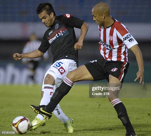 San Lorenzo's Roviro vies for the ball with River's Ronaldo Conceicao during the River vs San Lorenzo Copasudam football match in Montevideo October...