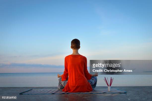 woman practicing yoga and meditation at dawn - new age stock pictures, royalty-free photos & images
