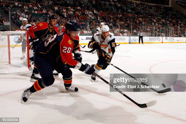 Kamil Kreps of the Florida Panthers battles for the puck against Craig Rivet of the Buffalo Sabres at the BankAtlantic Center on October 21, 2009 in...