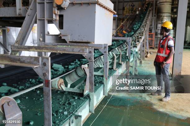 Man watches a conveyor belt loaded with chunks of Raw cobalt after a first transformation at a plant in Lubumbashi on February 16 before being...