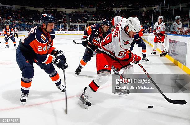 Chad LaRose of the Carolina Hurricanes controls the puck against Radek Martinek of the New York Islanders on October 21, 2009 at Nassau Coliseum in...