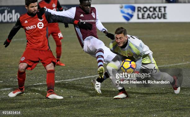 Toronto FC goalie Alexander Bono, right, grabs the ball after an attempt on the goal as Colorado Rapids player Dominique Badji, middle, tries to get...