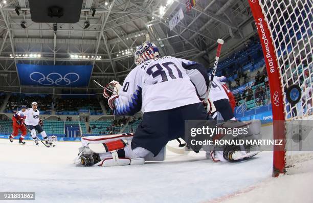 The puck shot by Jan Kolar of the Czech Republic sails past goalie Ryan Zapolski of the USA for a goal during the men's quarter-final ice hockey...