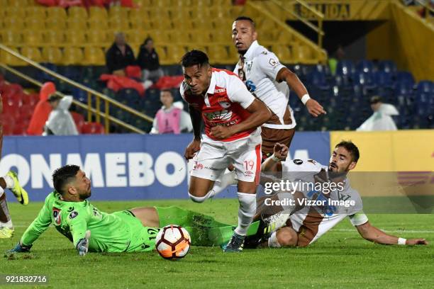 Wilson Morelo of Independiente Santa Fe fights for the ball with goalkeeper Mauricio Viana and Ezequiel Luna of Santiago Wanderers during a second...