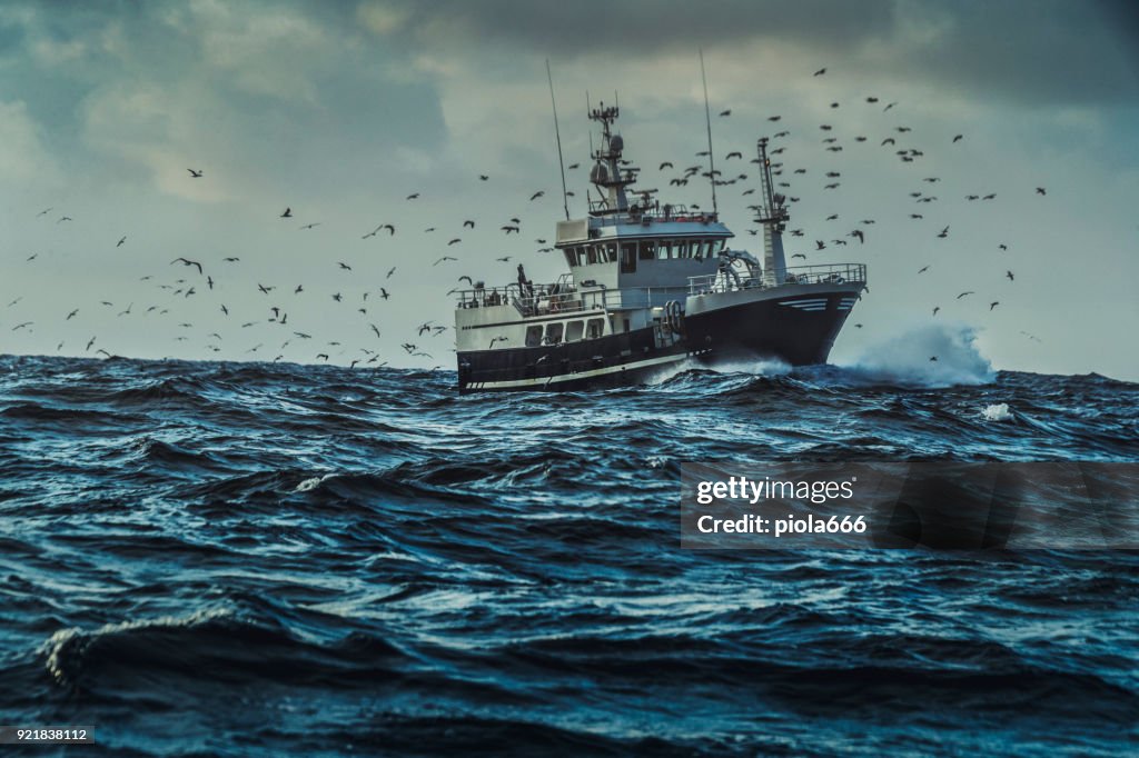 Fishing boat sailing at rough sea