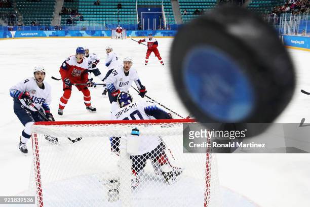 Players watch as the puck hits the glass in the first period of the Men's Play-offs Quarterfinals between the Czech Republic and the United States on...