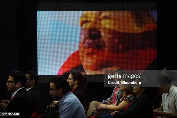 Digital screen displays an image of the late Venezuelan president Hugo Chavez as people attend the Petro cryptocurrency launch event in Caracas,...