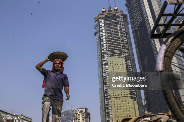 Worker labors as the two towers of Trump Tower Mumbai stand under construction at Lodha The Park, a luxury residential project developed by Lodha...