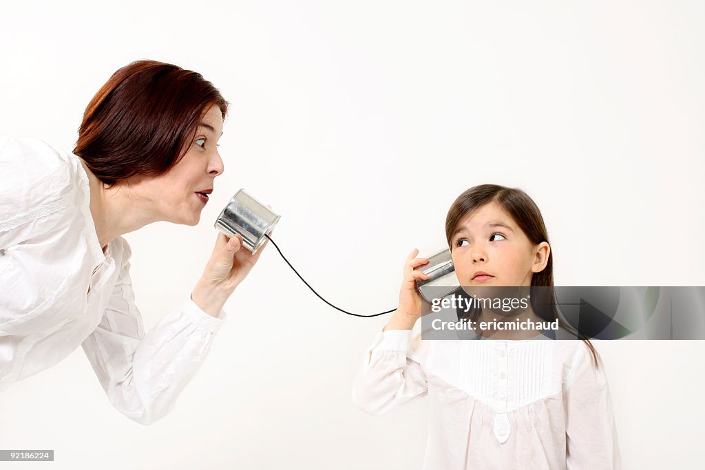 Mutter und Tochter, die mit einem Dosentelefon