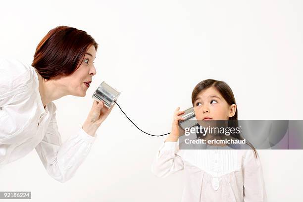 mother and daughter talking using a tin can phone - tin can phone stock pictures, royalty-free photos & images