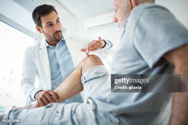 senior man having medical exam. - physiotherapy knee stock pictures, royalty-free photos & images