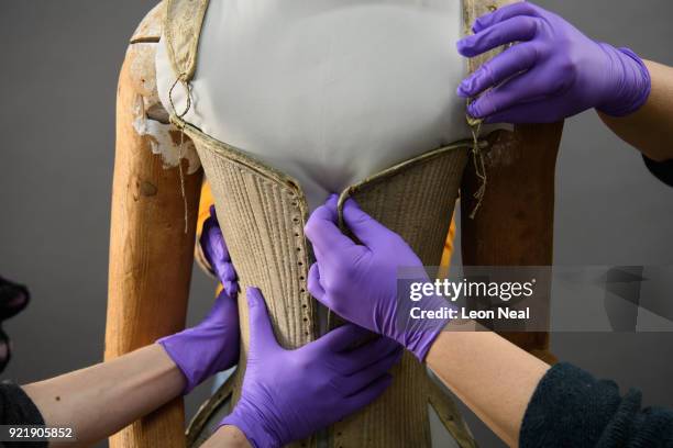 Members of the conservation team wear protective gloves during the fitting of a 'pair of straight bodies' to the funeral effigy of Elizabeth I at...