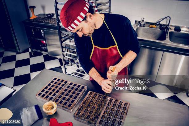 confectioner makes chocolate pieces - belgium chocolate stock pictures, royalty-free photos & images