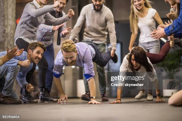 wheelbarrow race on a break in the office! - businesswoman handstand stock pictures, royalty-free photos & images