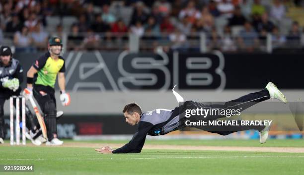 New Zealand's Mitchell Santner fields a ball off his own bowling during the final Twenty20 Tri Series international cricket match between New Zealand...