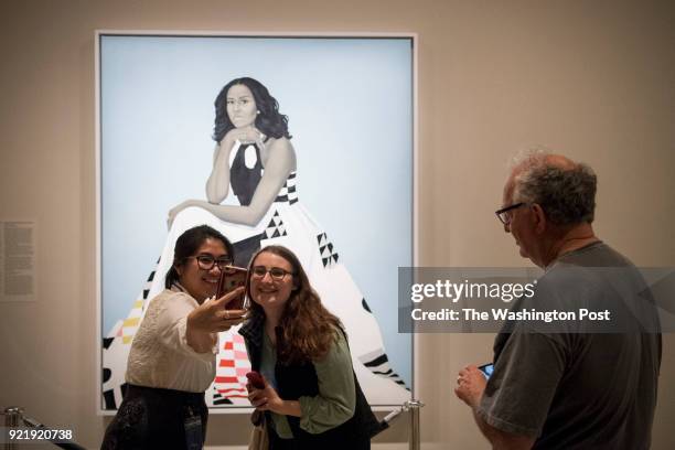 Christine Baltazar, left, and Giulia Arostegui take a selfie with the commissioned portrait of Michelle Obama by Amy Sherald at the Smithsonian's...