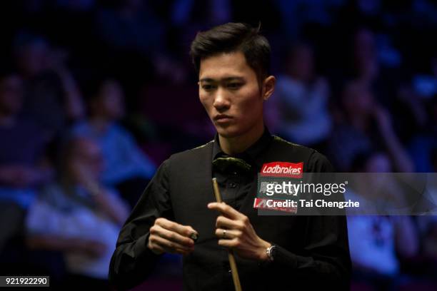 Cao Yupeng of China chalks the cue during his first round match against Anthony McGill of Scotland on day two of 2018 Ladbrokes World Grand Prix at...