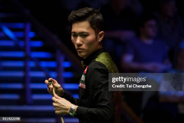 Cao Yupeng of China chalks the cue during his first round match against Anthony McGill of Scotland on day two of 2018 Ladbrokes World Grand Prix at...