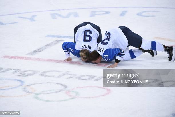 Finland's Venla Hovi and Michelle Karvinen kiss the ice after winning the women's bronze medal ice hockey match between Finland and the Olympic...