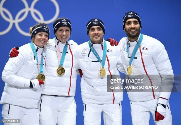 France's gold medallists Marie Dorin Habert, Anais Bescond, Simon Desthieux and Martin Fourcade pose on the podium during the medal ceremony for the...